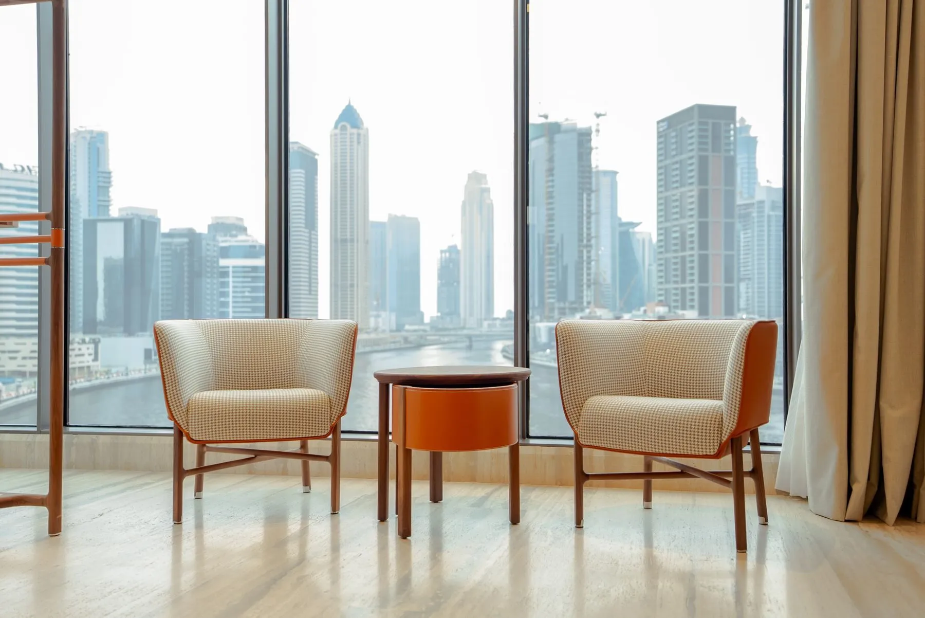 Living room of a Shreevardhan home opening onto a balcony with a view of the Pune skyline