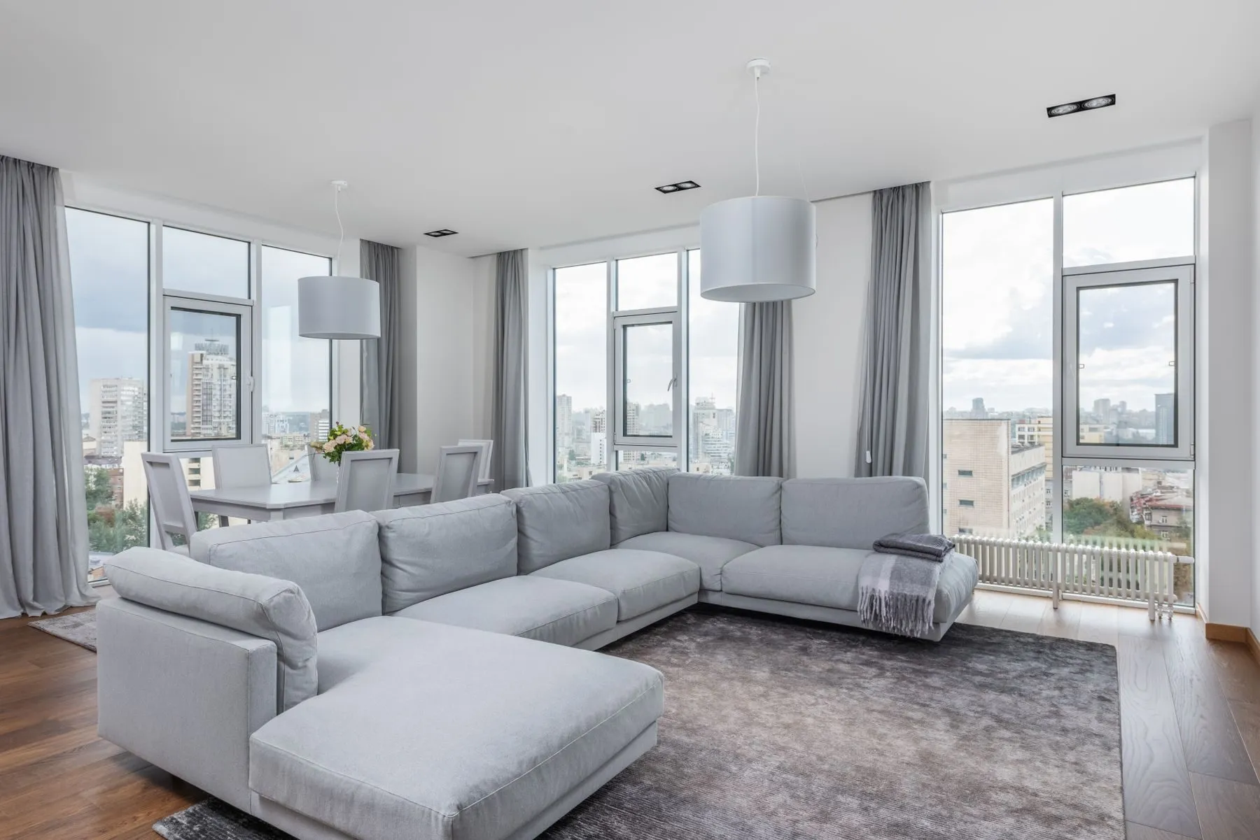 Spacious living room with floor-to-ceiling windows overlooking the city